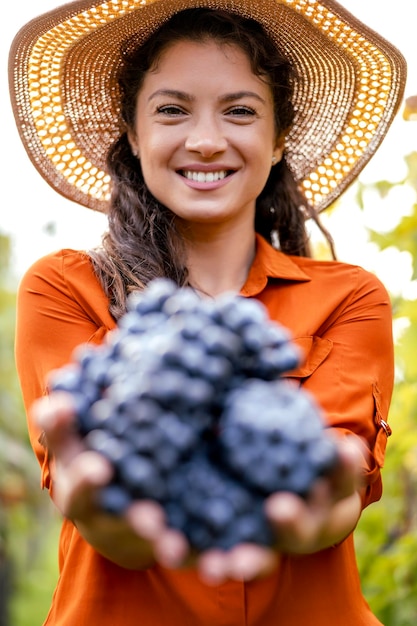 Retrato de mujer cosechando uvas