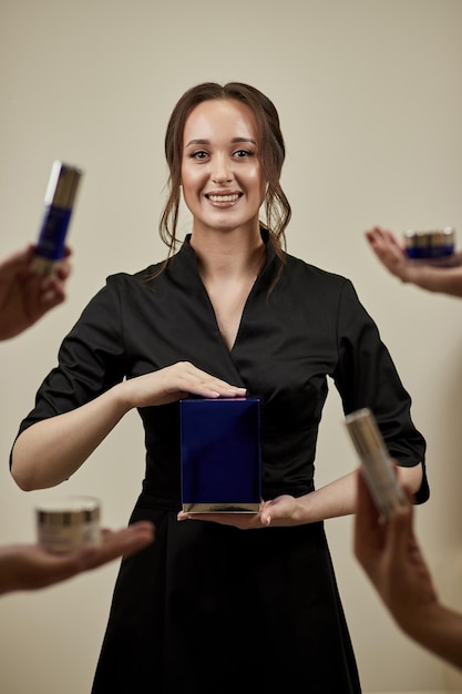 Retrato de mujer cosmetóloga sonriente con diferentes bancos de cremas Esteticista femenina en su lugar de trabajo en la clínica de cosmetología