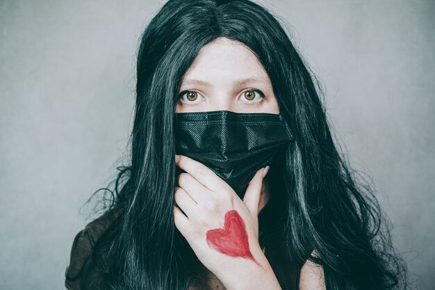 Retrato de una mujer cubriendo el rostro contra la pared