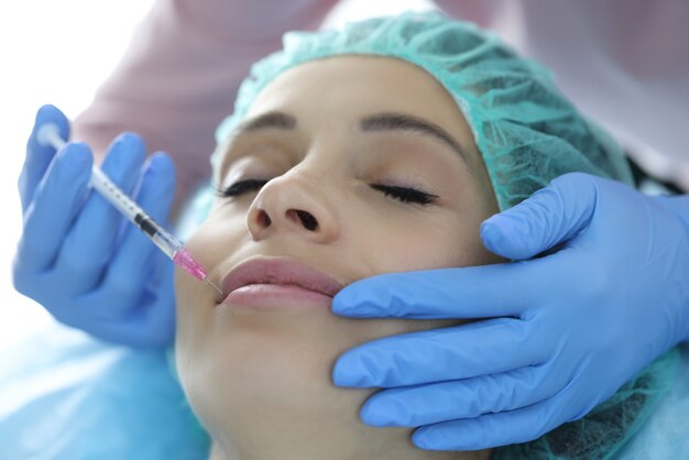 Retrato de mujer cuyos labios son inyectados por esteticista