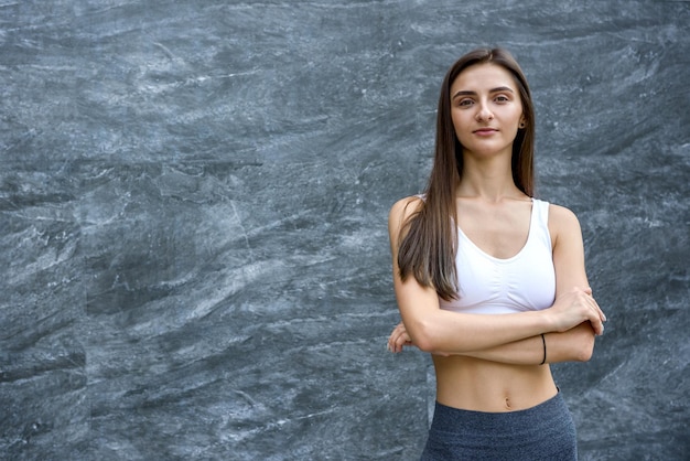 Retrato de mujer delgada y deportiva sobre fondo abstracto. Deporte y salud