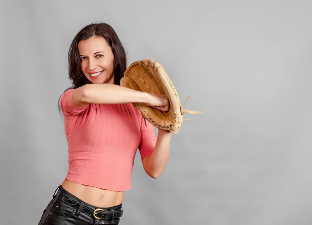 Retrato de mujer delgada sosteniendo un gran guante de béisbol en la mano Vida activa del juego deportivo