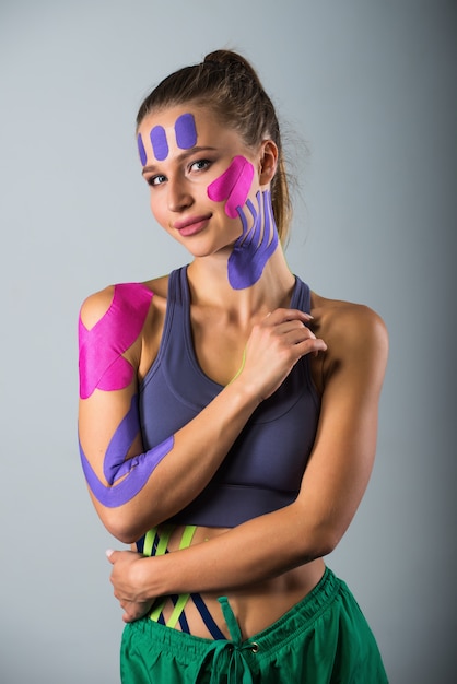 Retrato de mujer deportiva en cintas terapéuticas kinesio