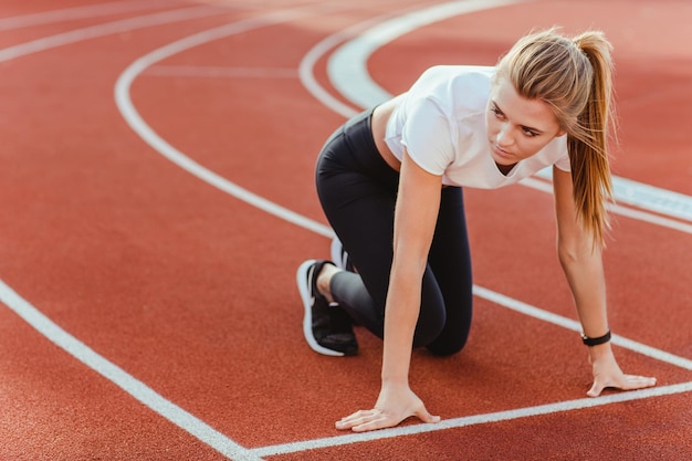 Retrato de una mujer deportiva esperando la señal de inicio para ejecutar