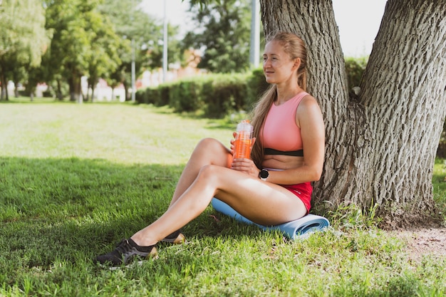 Retrato de una mujer deportiva con pelo largo en ropa deportiva en el parque