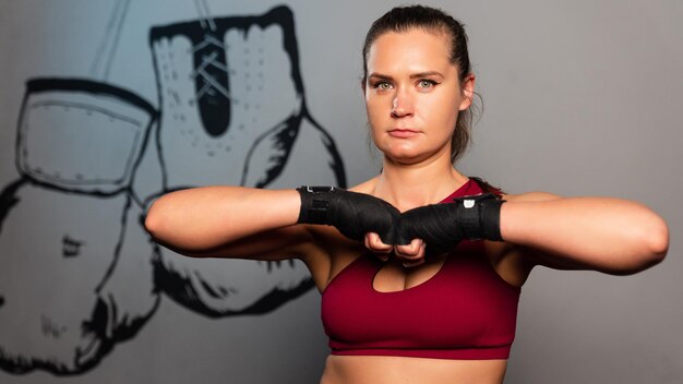 Foto retrato de una mujer deportiva con vendajes de boxeo en las manos