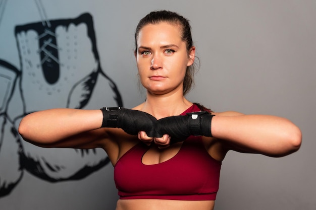 Retrato de una mujer deportiva con vendas de boxeo en las manos