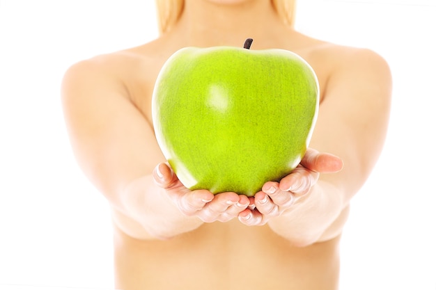 Retrato de una mujer desnuda sosteniendo manzana artificial aislado sobre fondo blanco.