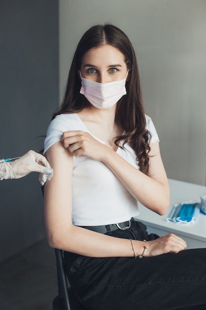 Retrato de mujer después de que ella es vacunada joven en una habitación de hospital