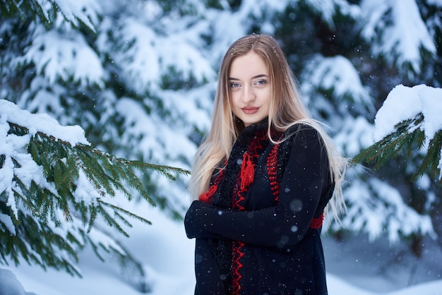 Retrato de mujer en día de invierno sobre fondo de paisaje nevado