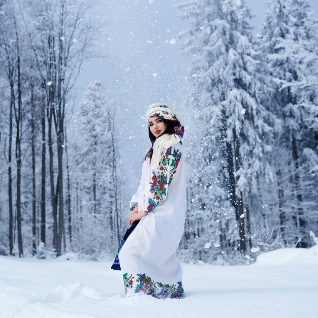 Retrato de mujer en día de invierno sobre fondo de paisaje nevado