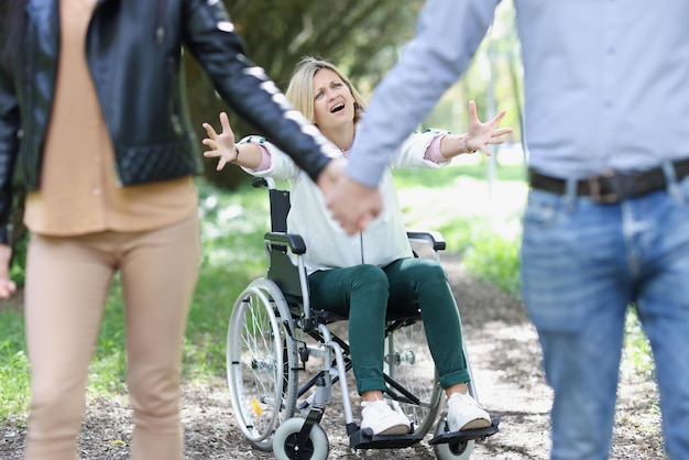 Foto retrato de mujer discapacitada en silla de ruedas gritando o llorando pareja dejando mujer frustrada