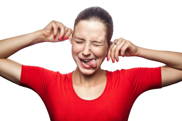 Retrato de mujer divertida loca en camiseta roja con pecas mirando a la cámara