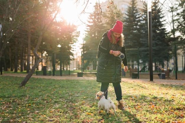 Retrato mujer dueño de una mascota paseando perro jack russell terrier en ropa divertida en la calle al aire libre pet ca