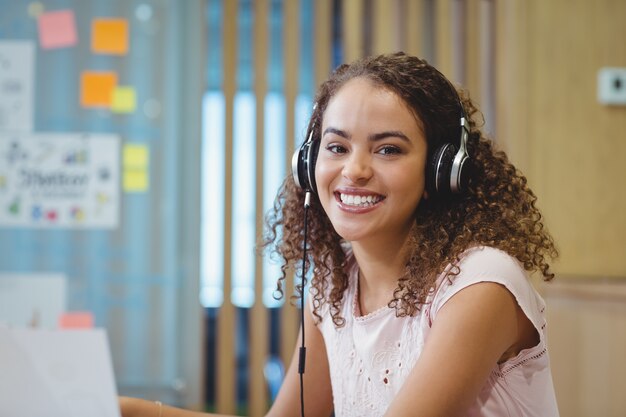 Retrato de mujer ejecutiva escuchando música en auriculares