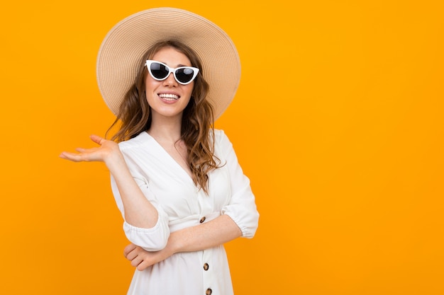 Retrato de una mujer elegante con un sombrero blanco sobre un amarillo