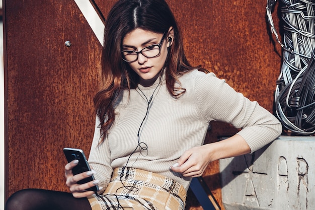 Foto retrato de mujer elegante sosteniendo teléfono móvil