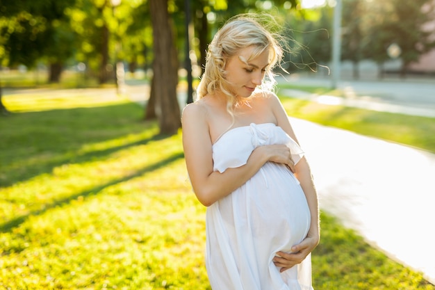 Retrato de una mujer embarazada feliz en un parque