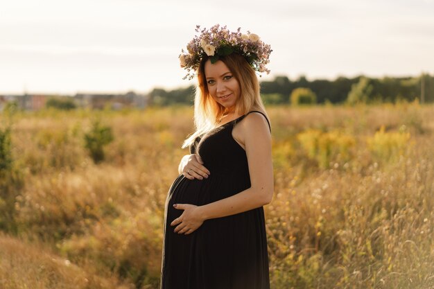 Foto retrato de una mujer embarazada una hermosa joven embarazada con un vestido blanco camina en el campo