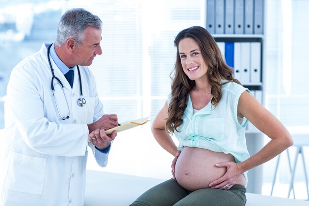 Retrato de mujer embarazada con médico