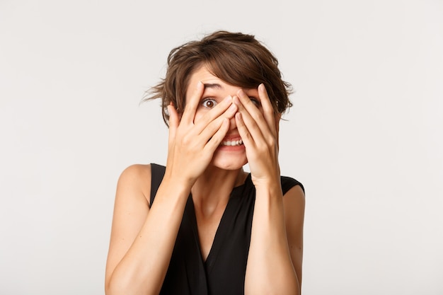 Foto retrato de mujer emocionada leerlo a través de los dedos divertido aislado