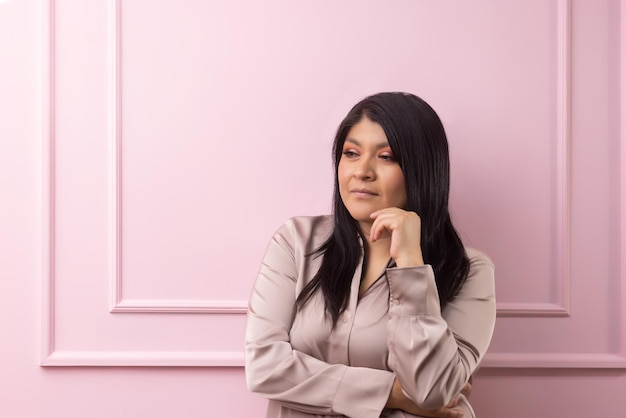 Retrato de una mujer empoderada mexicana aislada sobre fondo rosa