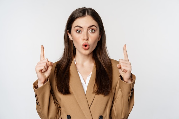 Retrato de una mujer empresaria empresaria apuntando con el dedo hacia arriba sonriendo confiada mostrando un anuncio...