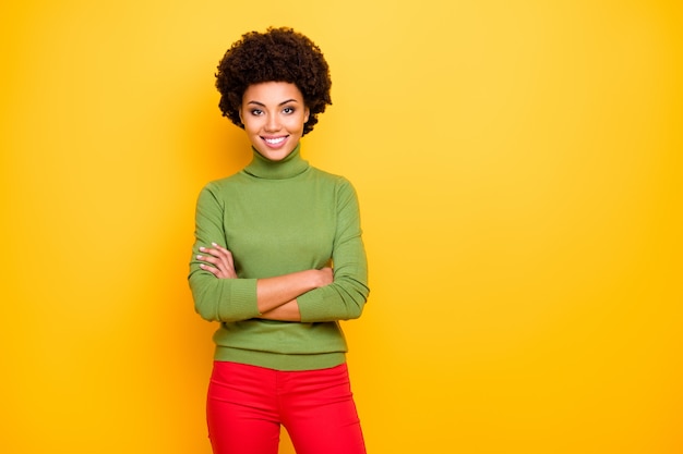 Retrato de mujer encantadora bonita bonita bonita alegre positiva con las manos dobladas en pantalones rojos sonriendo con dientes cerca del espacio vacío.