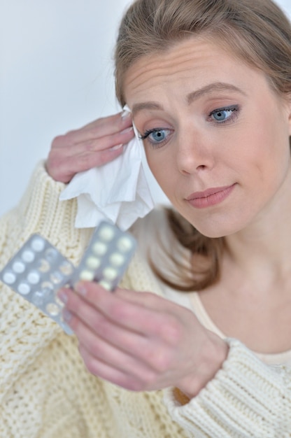 Retrato de mujer enferma con pastillas en casa