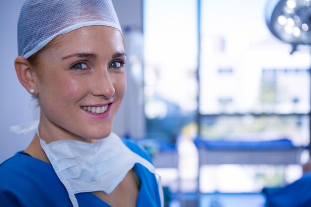 Retrato de mujer enfermera sonriendo en quirófano