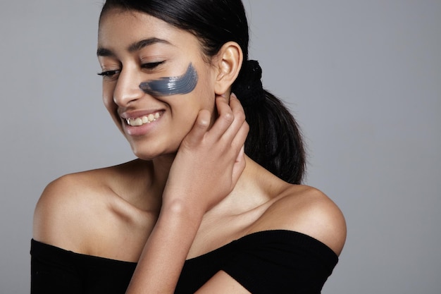 Retrato de mujer de enfoque suave con una mancha de crema en la mejilla