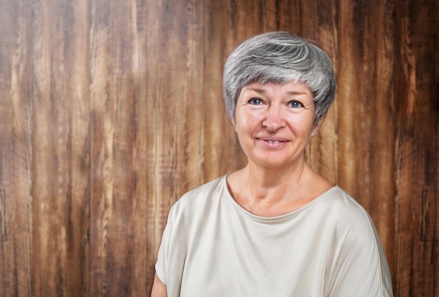 Foto retrato de la mujer enior sobre fondo de madera