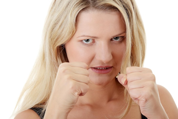 Retrato de una mujer enojada mostrando los puños contra un fondo blanco