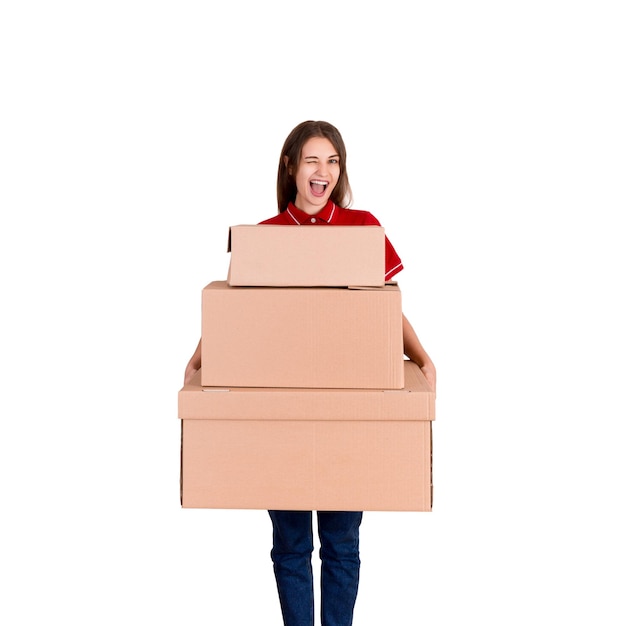 Retrato de una mujer de entrega sonriente sosteniendo paquetes pesados apilados contra un fondo blanco