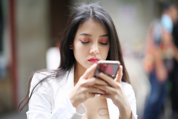 Retrato de mujer enviando mensajes de texto por teléfono móvil