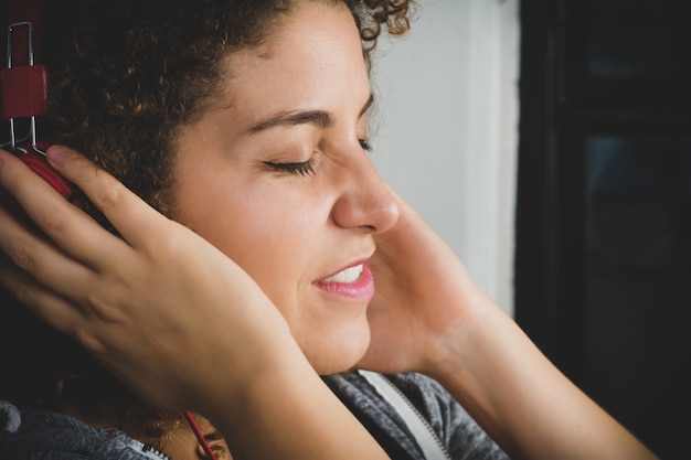 Retrato de mujer escuchando música con auriculares