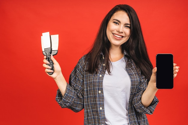 retrato, de, mujer, con, espátulas, aislado, encima, fondo rojo, actuación, pantalla de teléfono móvil