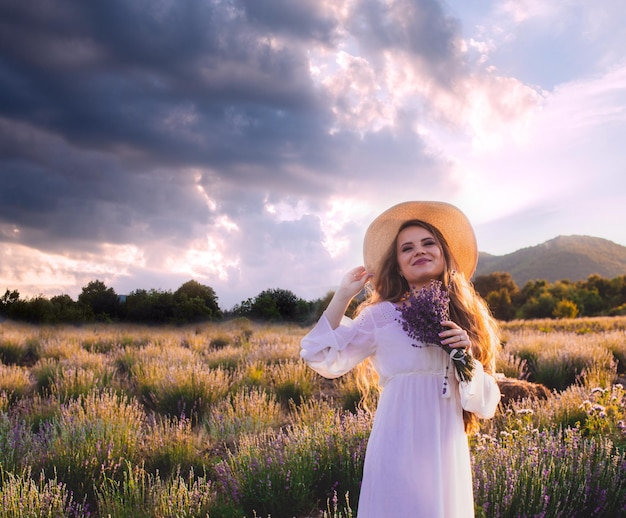 Retrato de mujer está de pie entre las plantaciones de lavanda