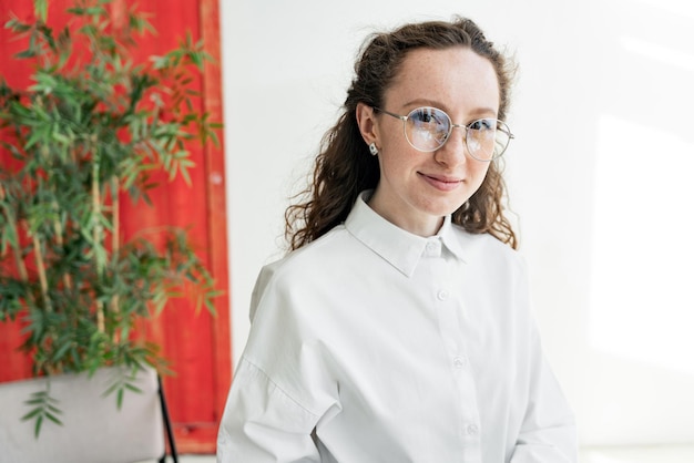 Retrato de una mujer con estilo de negocios de diseñador de gafas en el lugar de trabajo de la oficina