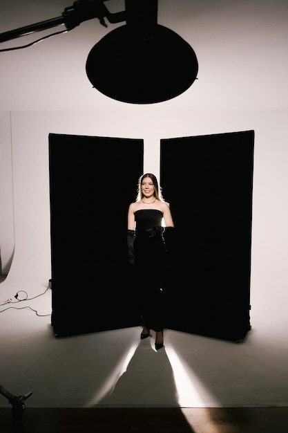 Retrato de una mujer en un estudio con iluminación profesional en un vestido elegante con guantes