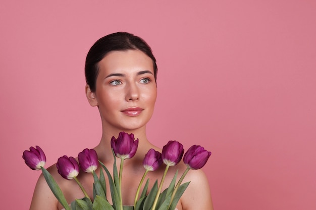 Retrato de una mujer en el estudio sobre una superficie rosa