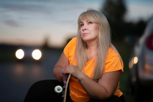 Retrato de una mujer europea gordo en una camiseta deportiva con una patineta