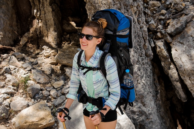 Retrato de mujer excursionista en gafas de sol con mochila