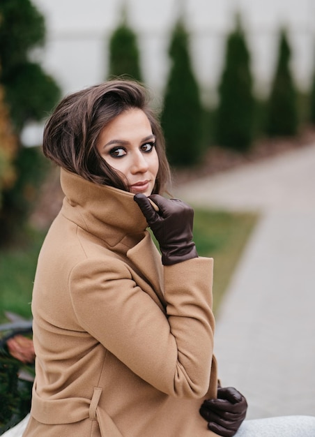 Retrato de una mujer feliz en una calle de la ciudad Hermosa chica de pie en la calle de otoño