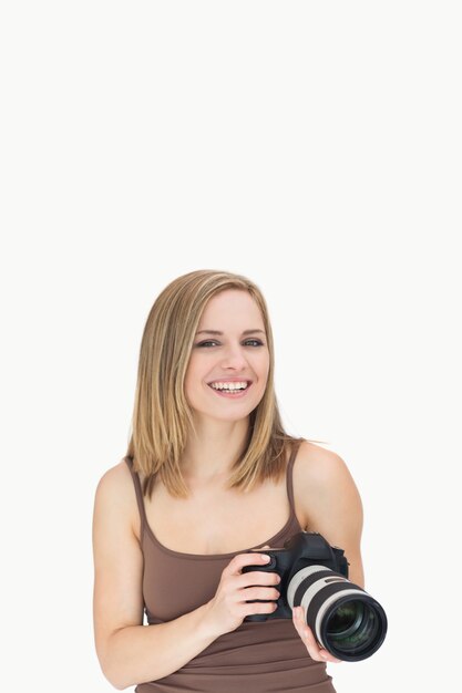 Retrato de mujer feliz con cámara fotográfica