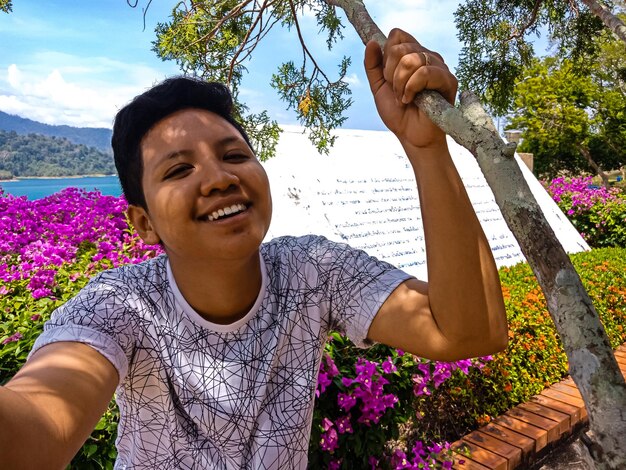 Foto retrato de una mujer feliz contra plantas de flores púrpuras