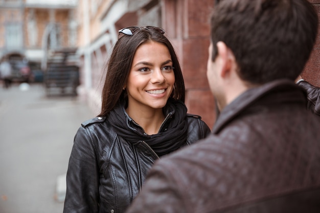 Retrato de una mujer feliz coqueteando con su novio al aire libre