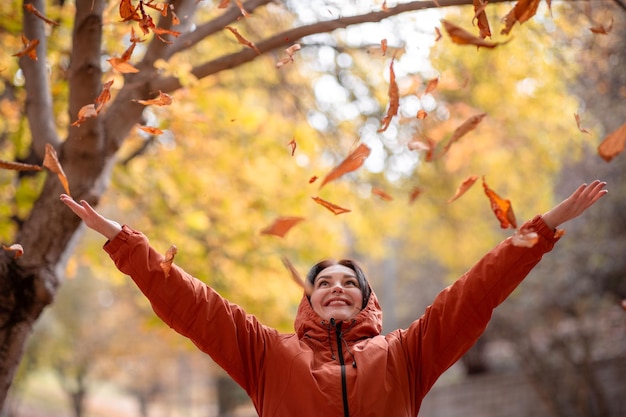 Retrato de mujer feliz y elegante en la temporada de otoño que posa con hoja amarilla