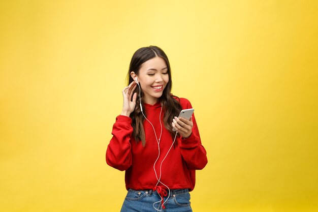 Retrato de una mujer feliz escuchando música con auriculares