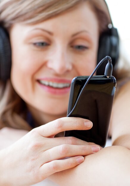 Retrato de una mujer feliz escuchando la música con auriculares